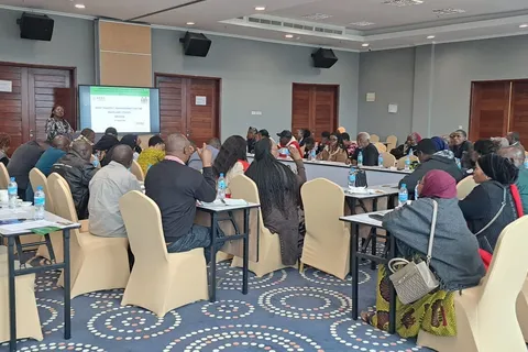Trainees seated at round tables during a post-harvest management training session in Arusha