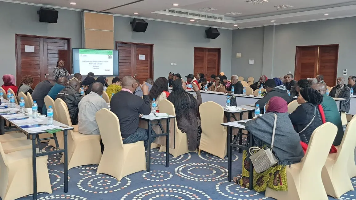Trainees seated at round tables during a post-harvest management training session in Arusha