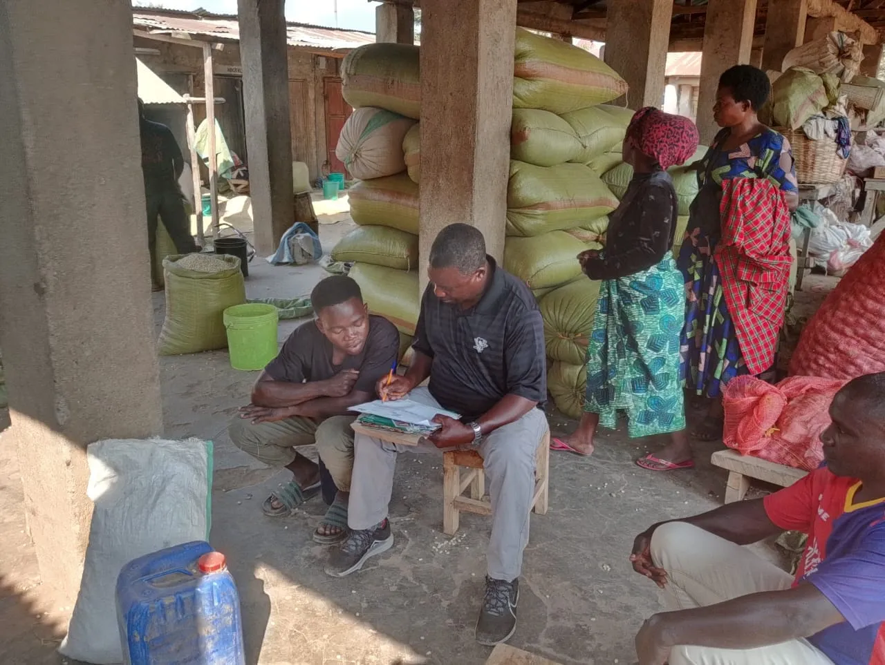 Traders at a grain aggregation center reviewing records