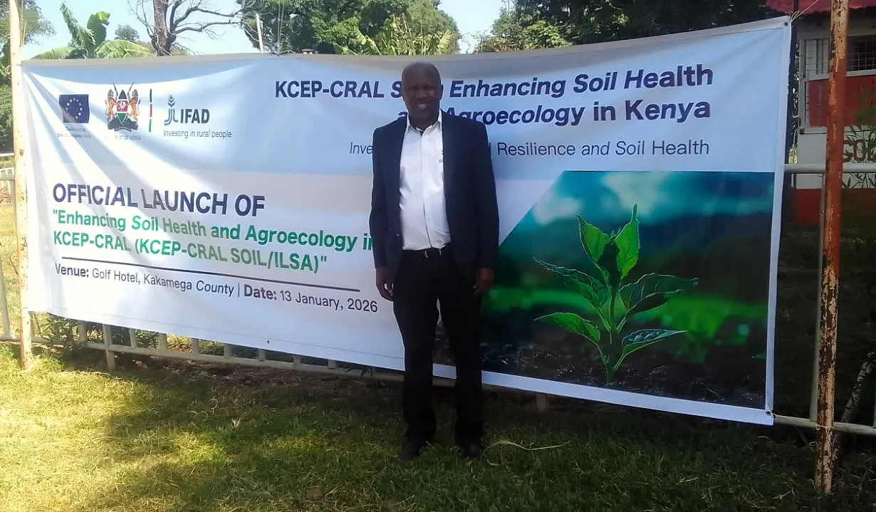 Man standing beside the official launch banner for the KCEP-CRAL Soil Health and Agroecology project in Kakamega
