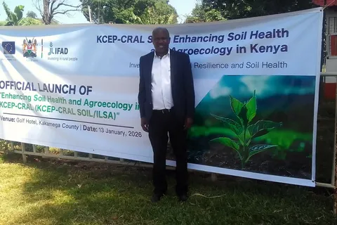 Man standing beside the official launch banner for the KCEP-CRAL Soil Health and Agroecology project in Kakamega