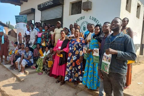 Group photo of traders at the Kasumulu CBTA formation event outside a village store