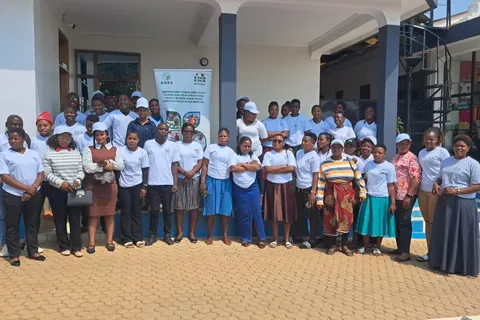 Group of CBTA trainees in matching white t-shirts posing outside a training venue in Tunduma