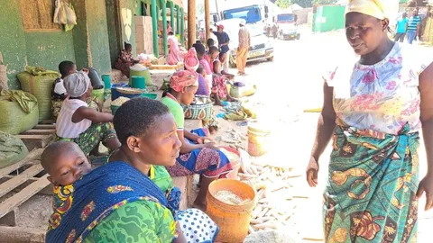 Women and children traders at an open-air grain market in the ESA cross-border trade region