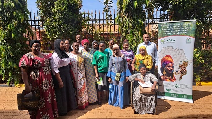 Group of diverse individuals at CBTA leadership training in Busia; colorful attire, AGRA banner featuring Africa map