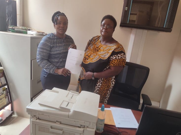 Ms. Vallary Adhiambo of AGMARK (Left), displaying signed MoU with Ms. Florence Atieno, Chairlady, Busia Women Cross Border Traders SACCO [Kenya]